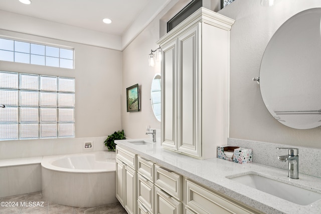 bathroom featuring tile patterned flooring, vanity, and a bath