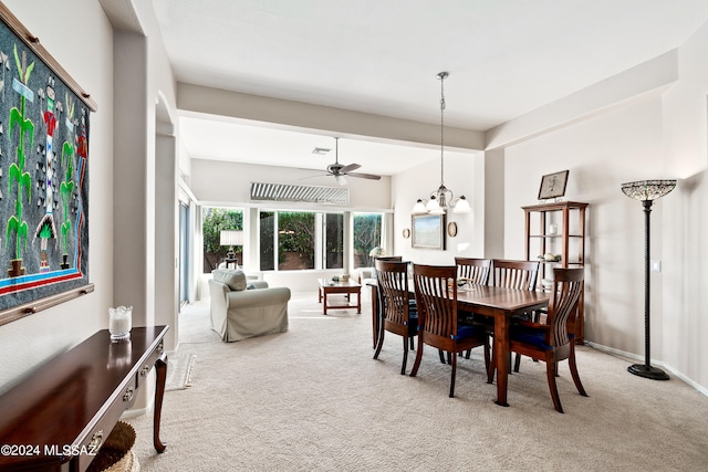 dining room with light colored carpet and ceiling fan with notable chandelier