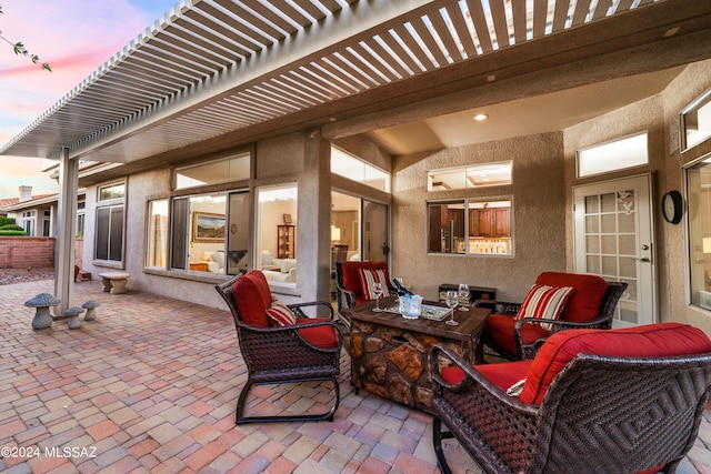 patio terrace at dusk featuring a pergola and an outdoor hangout area