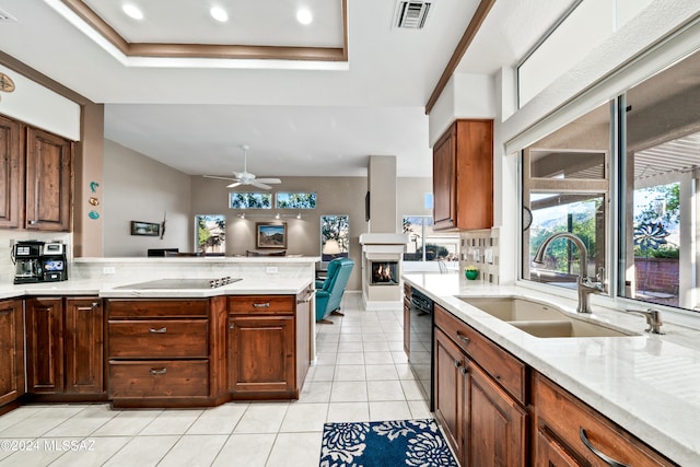 kitchen featuring black appliances, sink, ceiling fan, light tile patterned flooring, and a tray ceiling