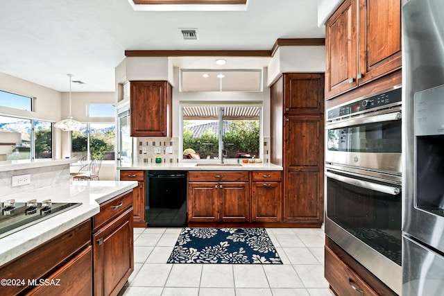 kitchen with black appliances, backsplash, decorative light fixtures, light tile patterned floors, and sink