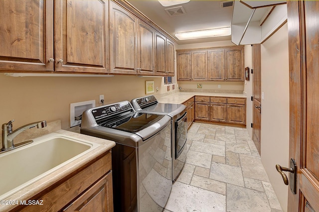 laundry area featuring cabinets, washer and dryer, and sink