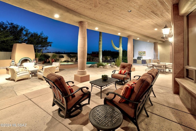 patio at night featuring an outdoor living space with a fireplace