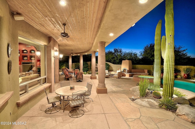 view of patio featuring exterior fireplace and ceiling fan