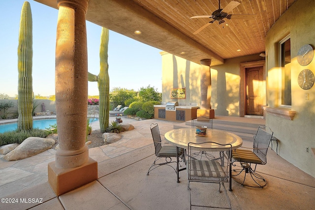 view of patio featuring a grill, ceiling fan, and exterior kitchen