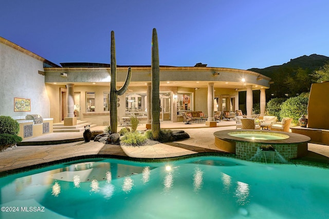 pool at dusk featuring an in ground hot tub, area for grilling, an outdoor living space, a mountain view, and a patio