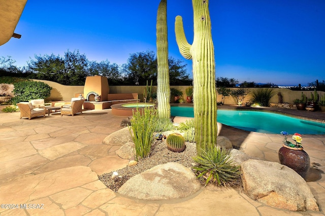 view of swimming pool with a patio and exterior fireplace