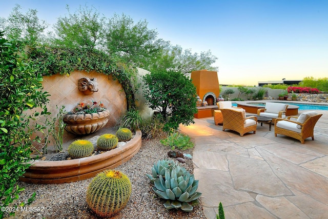 patio terrace at dusk with an outdoor living space with a fireplace