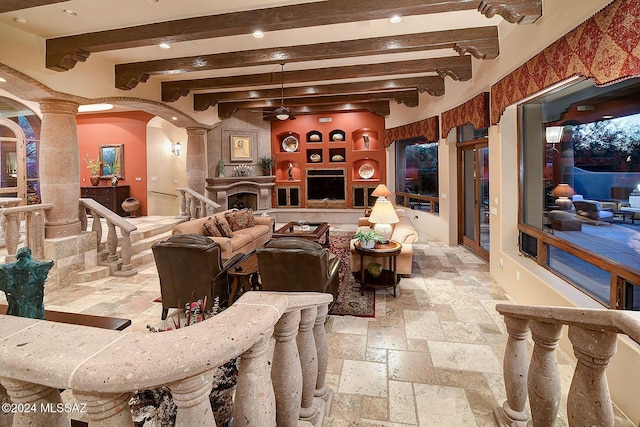 living room with beam ceiling and decorative columns