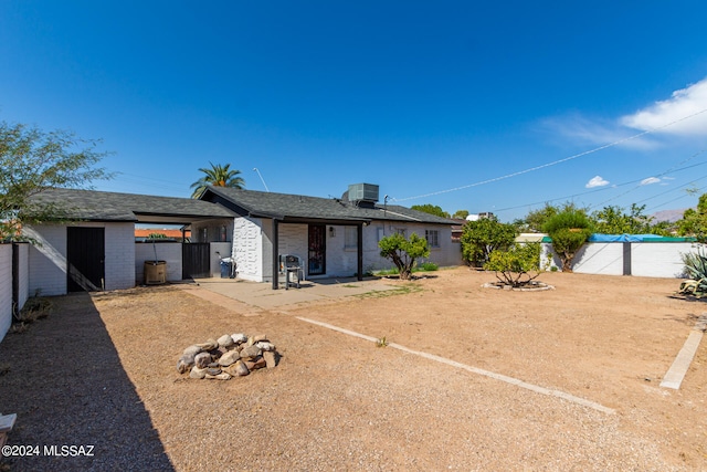 rear view of property featuring a carport and central AC unit