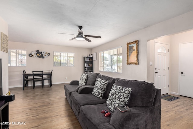 living room featuring ceiling fan, wood-type flooring, and plenty of natural light