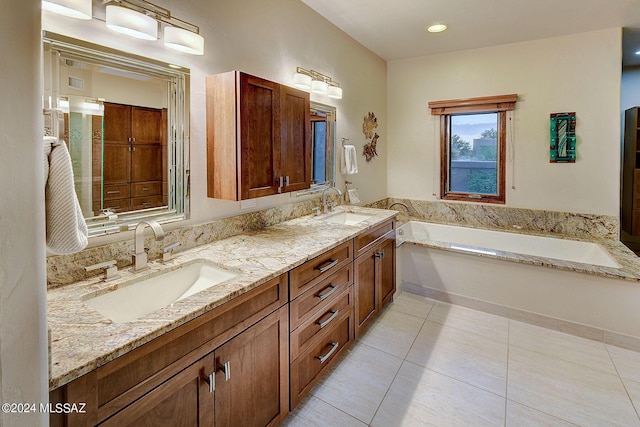 bathroom with a washtub, vanity, and tile patterned floors