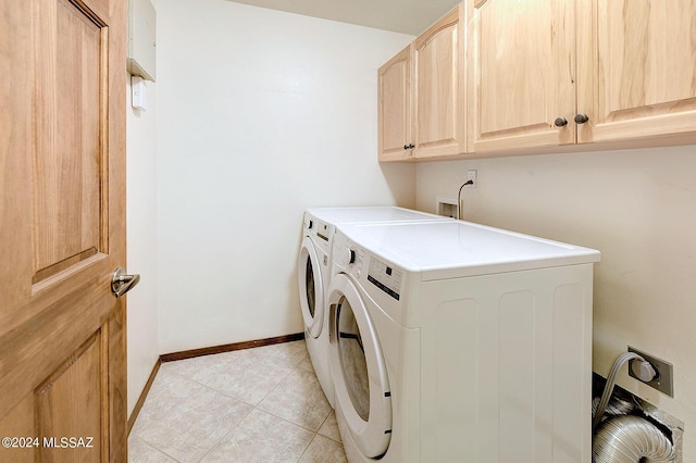 washroom featuring cabinets, washing machine and dryer, and light tile patterned flooring