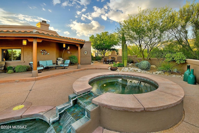 view of swimming pool with an outdoor living space, an in ground hot tub, pool water feature, and a patio area