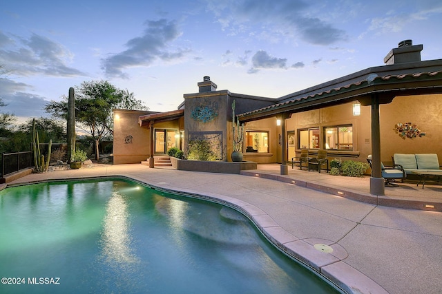 pool at dusk with a patio