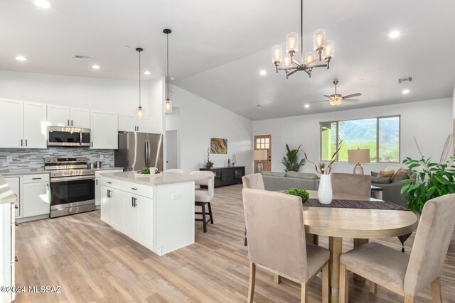 dining area with light wood-style flooring, recessed lighting, ceiling fan with notable chandelier, and visible vents