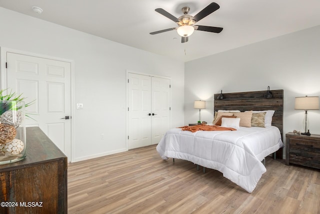 bedroom with baseboards, a closet, light wood finished floors, and ceiling fan