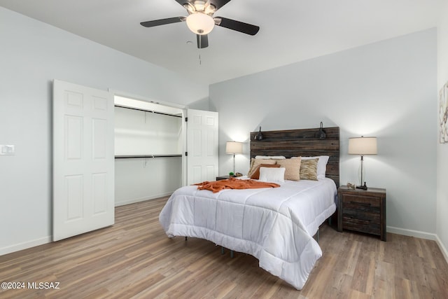 bedroom featuring a closet, a ceiling fan, baseboards, and wood finished floors