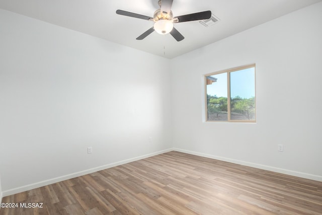 empty room with visible vents, ceiling fan, baseboards, and light wood-style floors