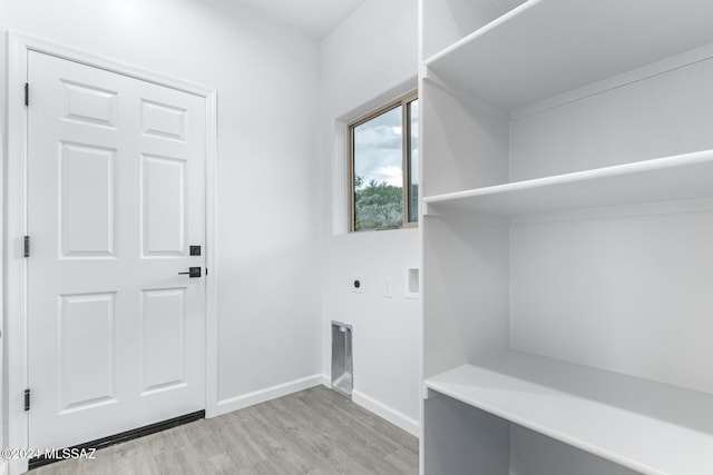 laundry area featuring laundry area, baseboards, light wood finished floors, and electric dryer hookup