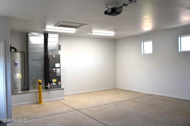 garage with baseboards, electric water heater, and a garage door opener