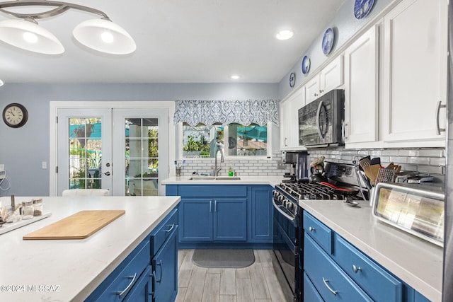 kitchen featuring white cabinetry, blue cabinetry, black appliances, french doors, and sink