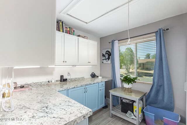 kitchen with white cabinetry, light hardwood / wood-style floors, and blue cabinetry