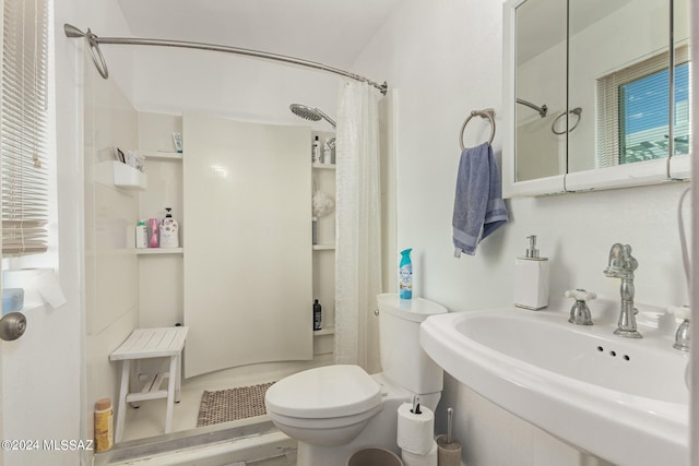 bathroom with sink, curtained shower, and toilet