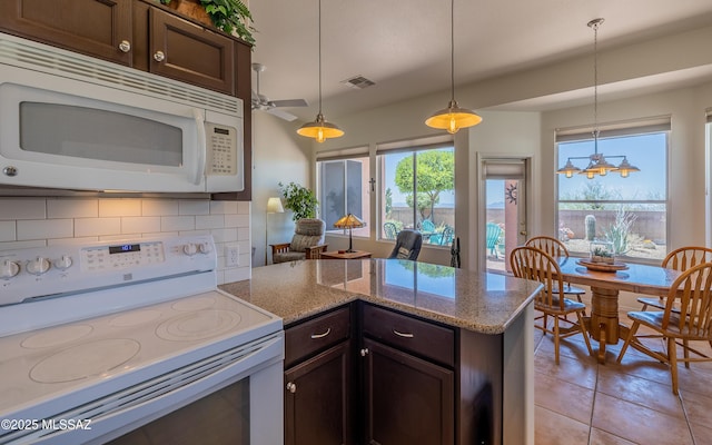 kitchen featuring dark brown cabinets, white appliances, decorative light fixtures, decorative backsplash, and a peninsula