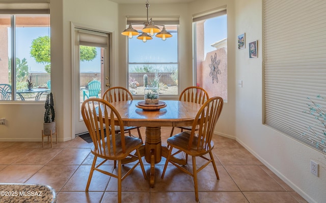 dining area with an inviting chandelier, baseboards, and light tile patterned floors