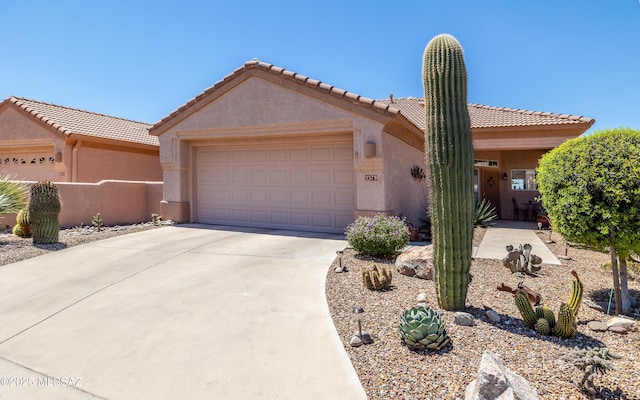 view of front of house featuring a garage, concrete driveway, and stucco siding