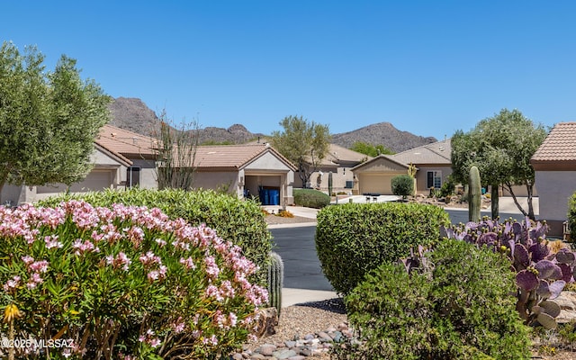 surrounding community with an attached garage and a mountain view