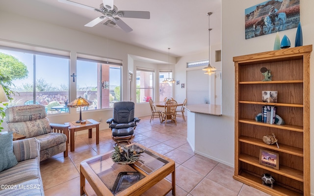 living room featuring a ceiling fan, baseboards, and light tile patterned floors