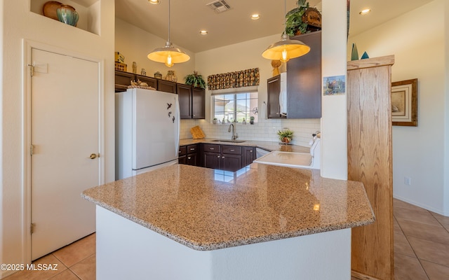 kitchen featuring visible vents, freestanding refrigerator, a sink, and light tile patterned flooring