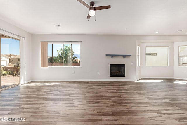 unfurnished living room with wood-type flooring and ceiling fan