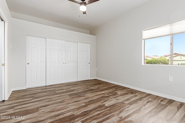 unfurnished bedroom with a closet, hardwood / wood-style flooring, and ceiling fan