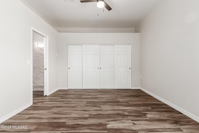 unfurnished bedroom with a closet, dark wood-type flooring, and ceiling fan