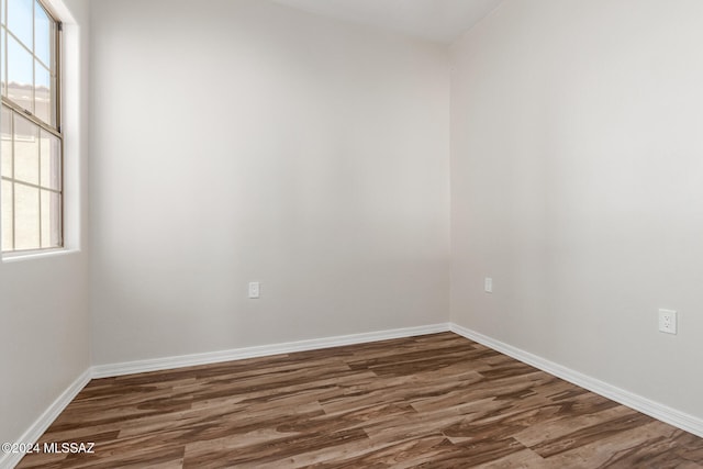 unfurnished room with dark hardwood / wood-style flooring