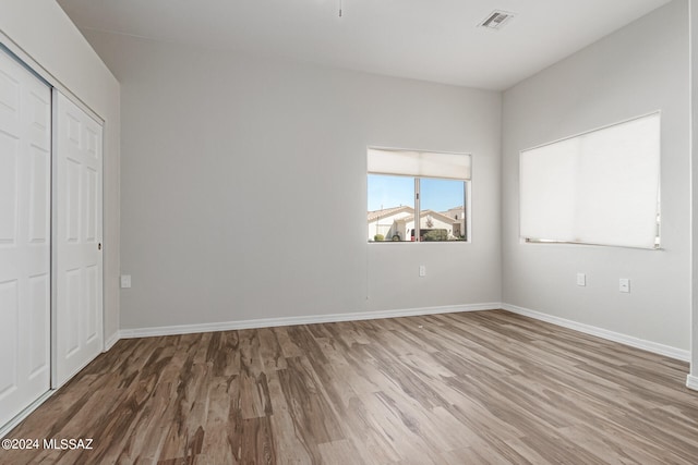 unfurnished bedroom with wood-type flooring and a closet