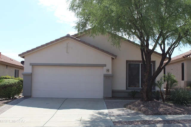 ranch-style house featuring concrete driveway, stucco siding, an attached garage, and a tile roof