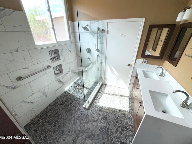 full bathroom with double vanity, a sink, and a walk in shower