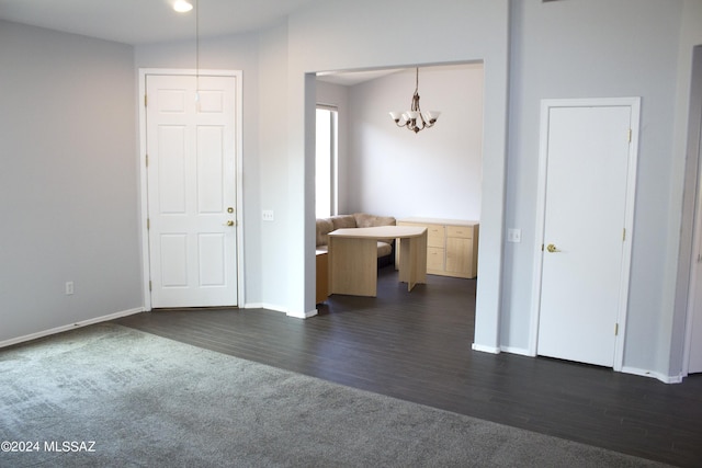 interior space with dark carpet, baseboards, dark wood finished floors, and an inviting chandelier