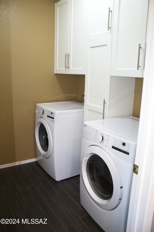 laundry area with baseboards, dark wood finished floors, cabinet space, and washer and dryer