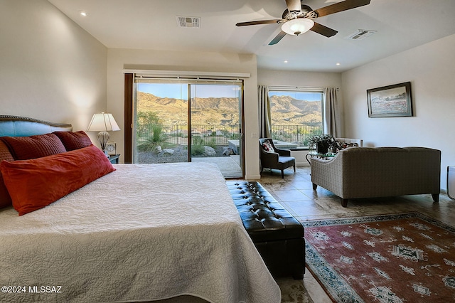 bedroom featuring a mountain view, access to exterior, multiple windows, and ceiling fan