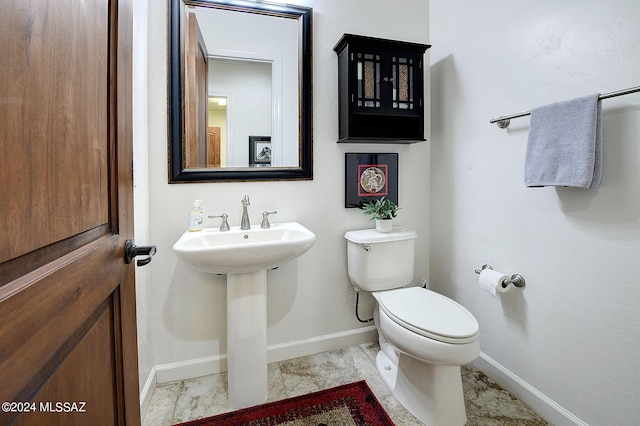 bathroom featuring toilet, sink, and tile patterned floors