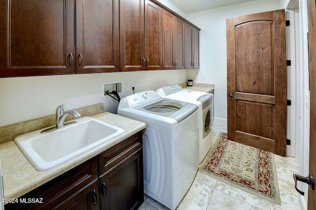 laundry area featuring sink, washer and dryer, light tile patterned flooring, and cabinets