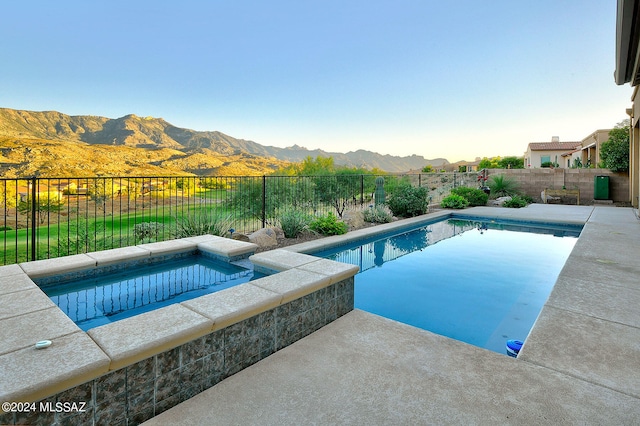 view of swimming pool featuring a patio, a mountain view, and an in ground hot tub