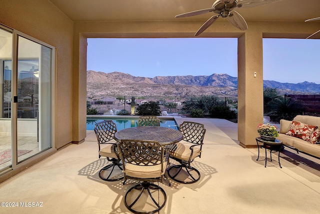 view of patio featuring a mountain view, a fenced in pool, and ceiling fan