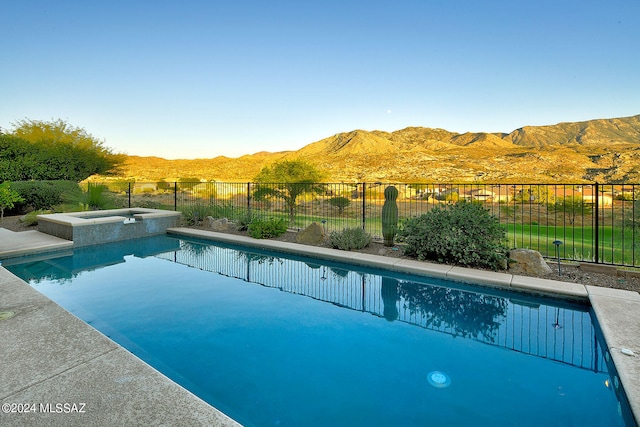 view of swimming pool featuring an in ground hot tub and a mountain view