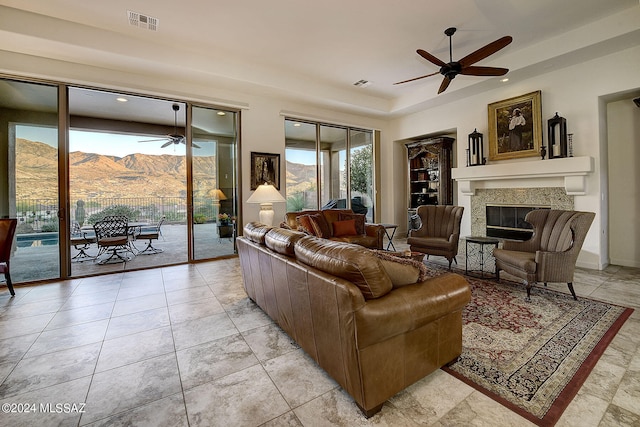 tiled living room with a mountain view and ceiling fan